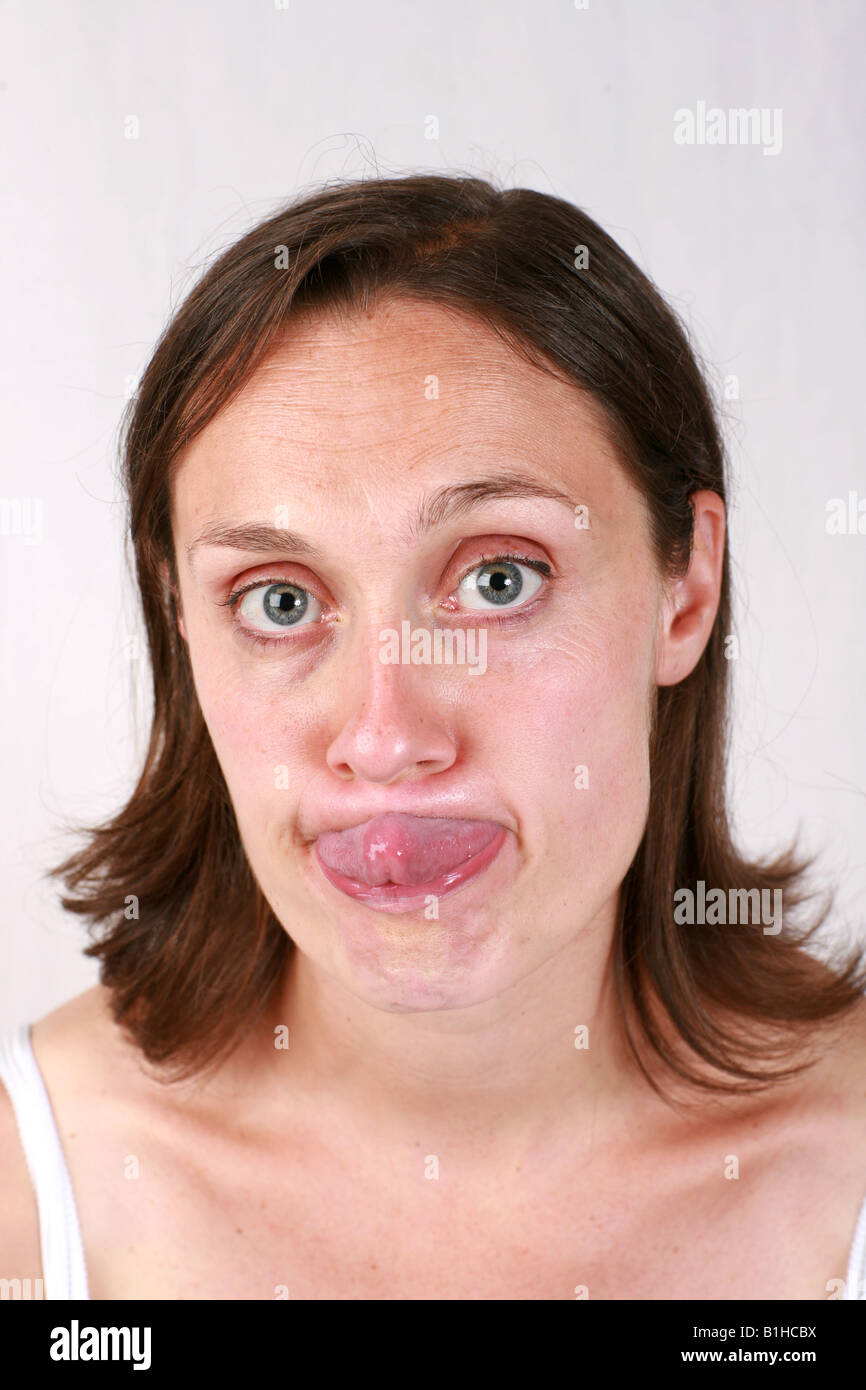 Young brunette woman closeup head and shoulders poking sticking tongue out  of mouth funny comical facial expression humorous Stock Photo - Alamy