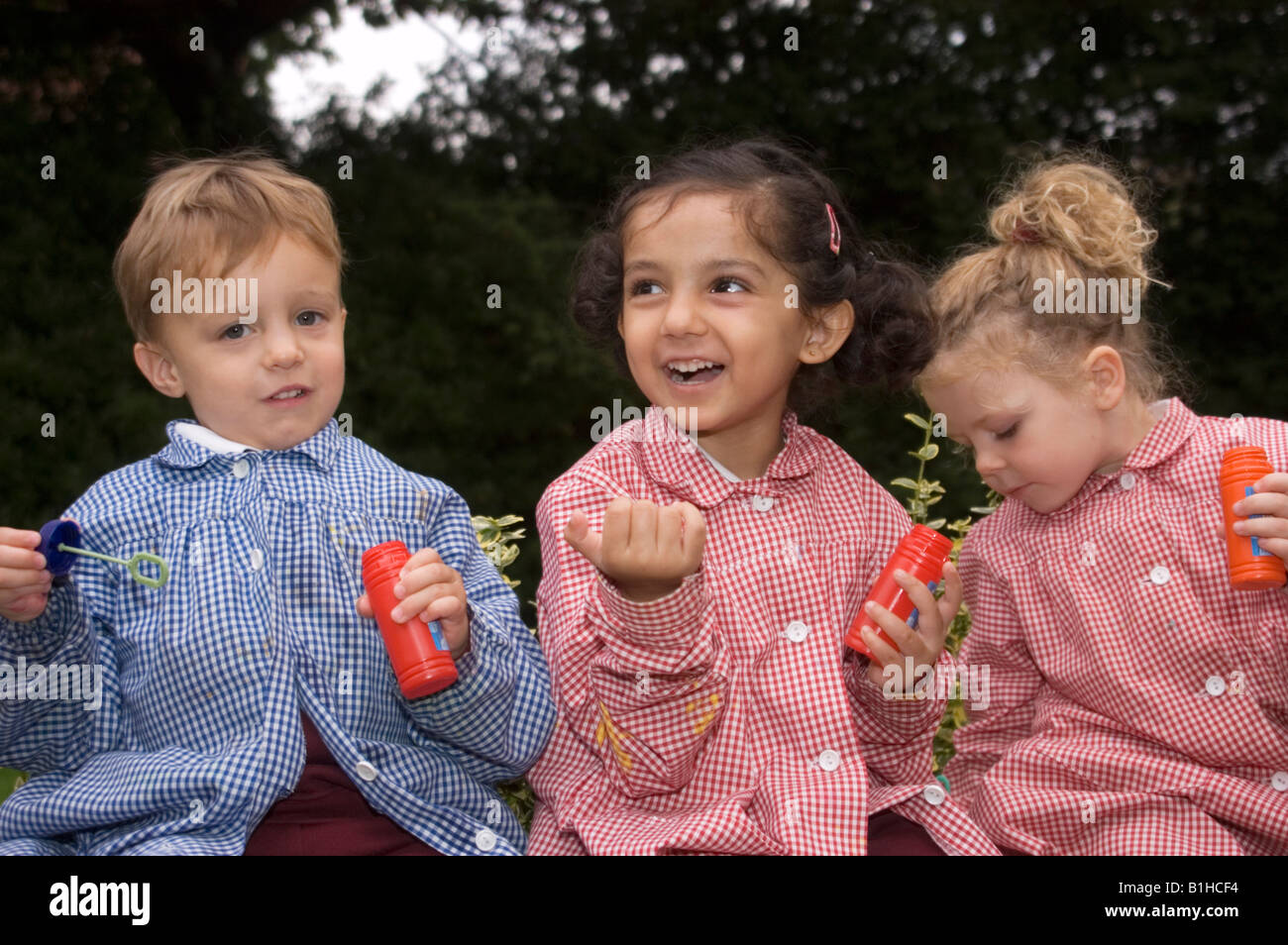 children at a private infant school playing with bubbles Stock Photo
