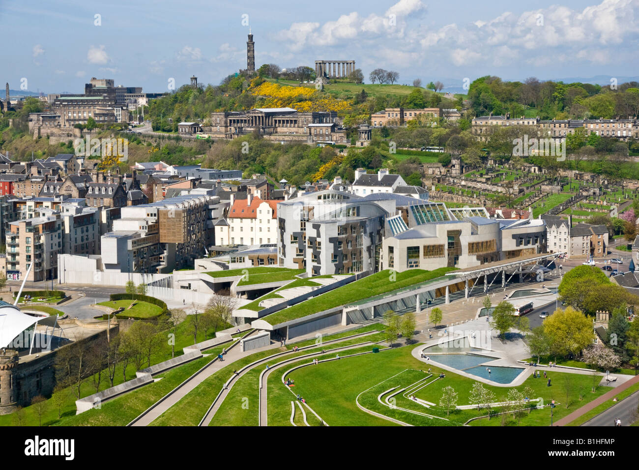 View of The Scottish Parliament and front lawn area with Calton Hill in Edinburgh Scotland on a sunny spring day Stock Photo