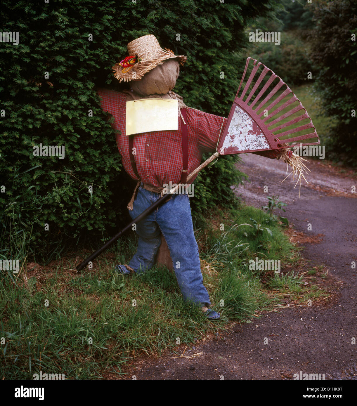 Scarecrow with a rake Stock Photo - Alamy
