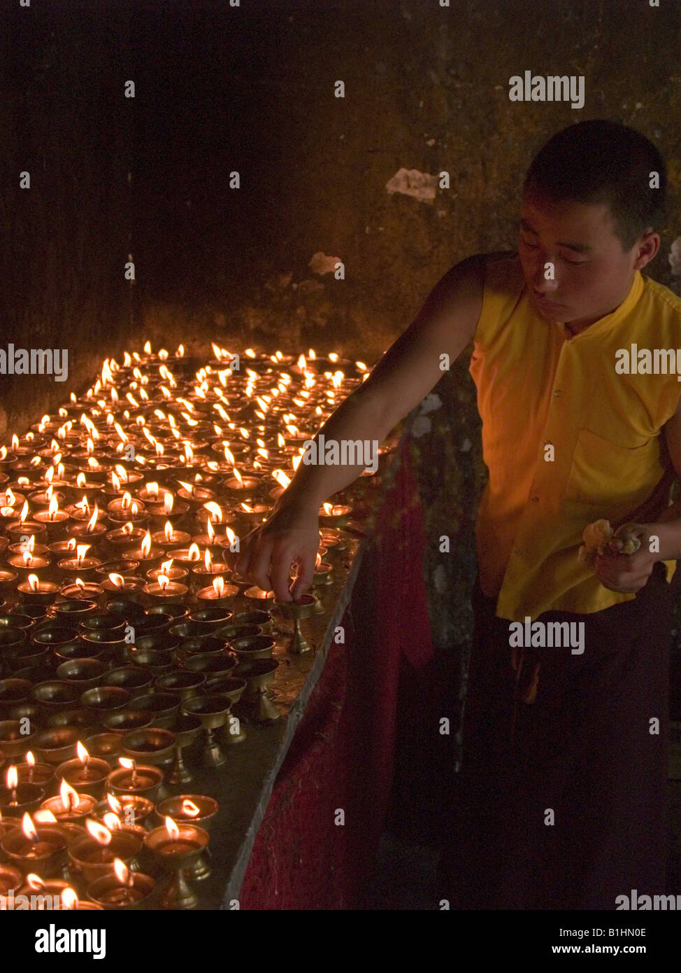 monk lighting butter candles at a Tibetan monastery in Sikkim Stock