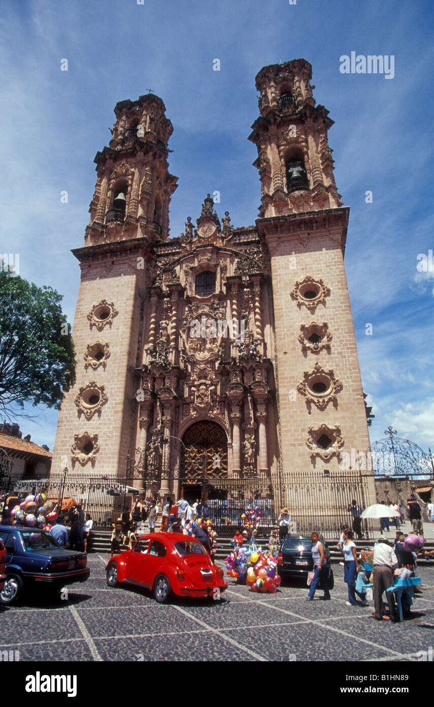 People and cars in front of the baroque style Santa Prisca Church in ...