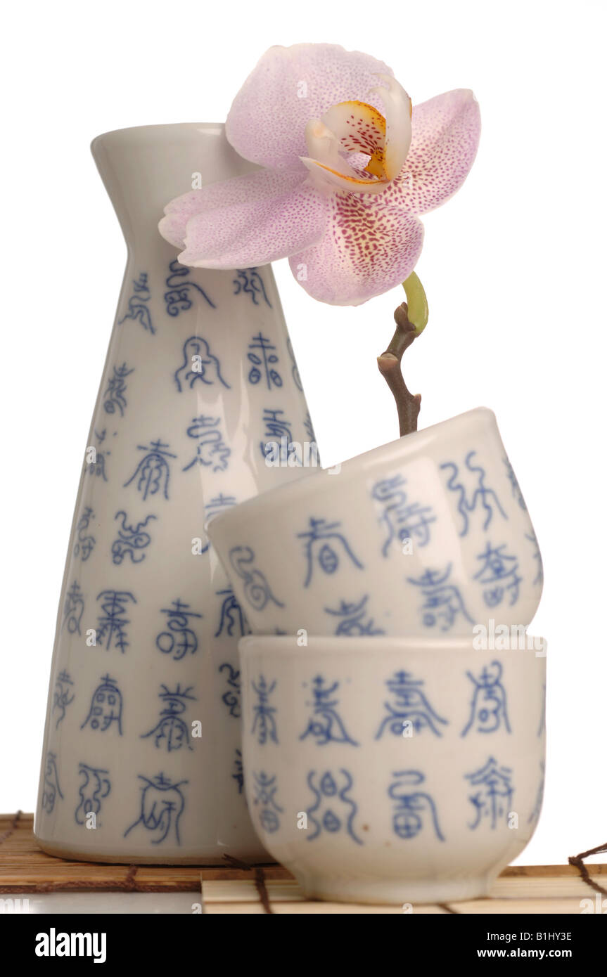 Asian crockey with blue characters and orchid blossom Stock Photo