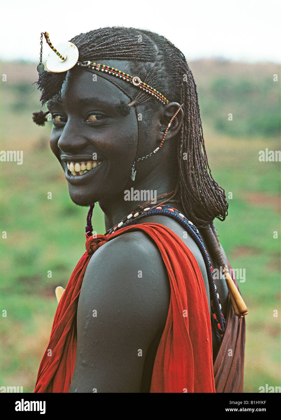 Maasai moran or warrior wears traditional beads and long hair Masai Mara National Reserve Kenya East Africa Stock Photo
