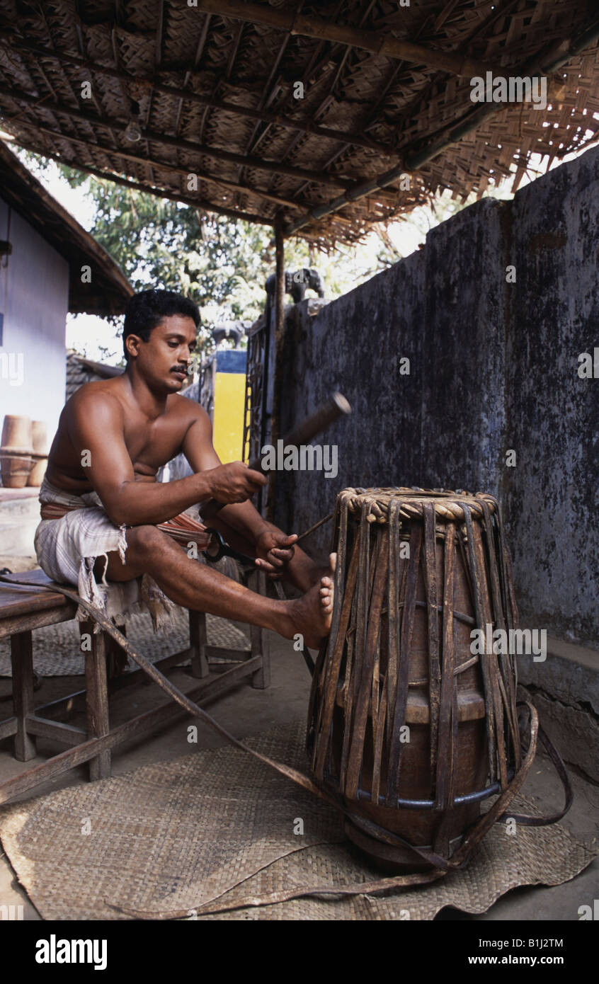 Young man making a Jendai a drum like leather musical instrument