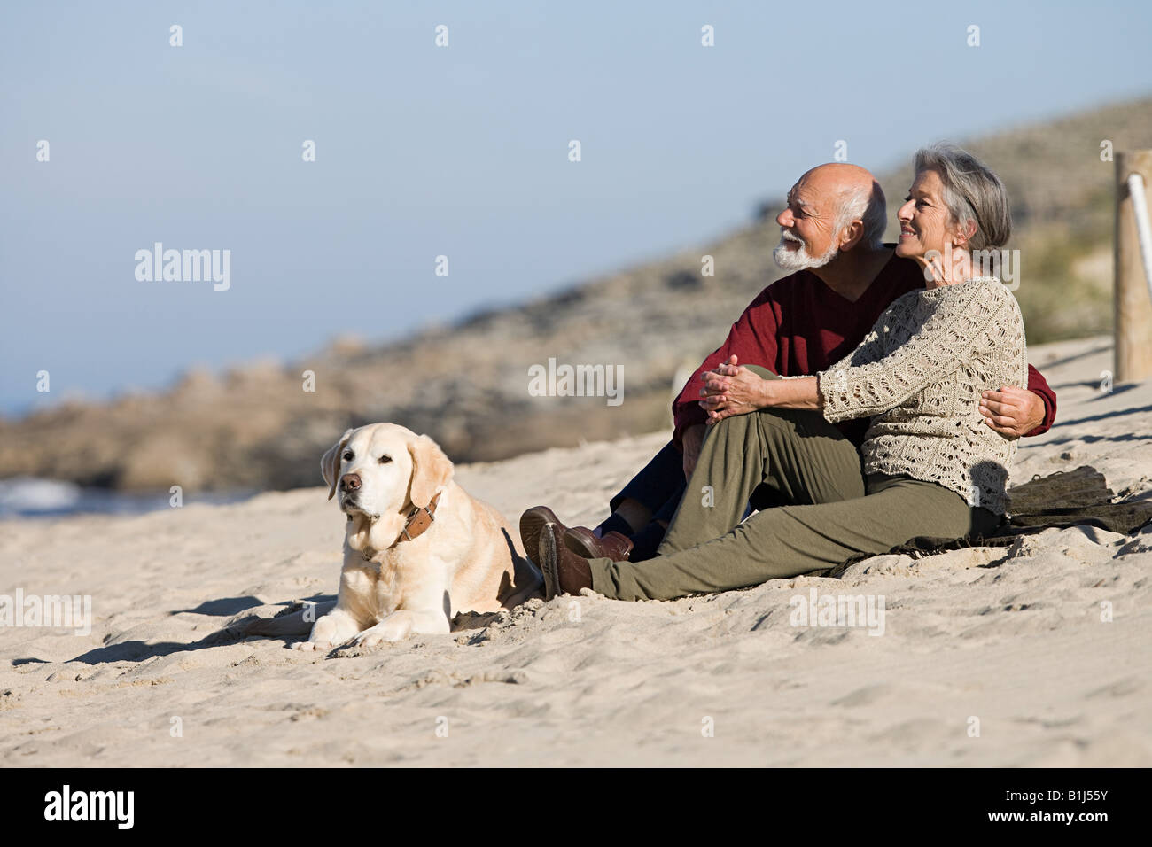 Senior couple relaxing on a beach Stock Photo - Alamy