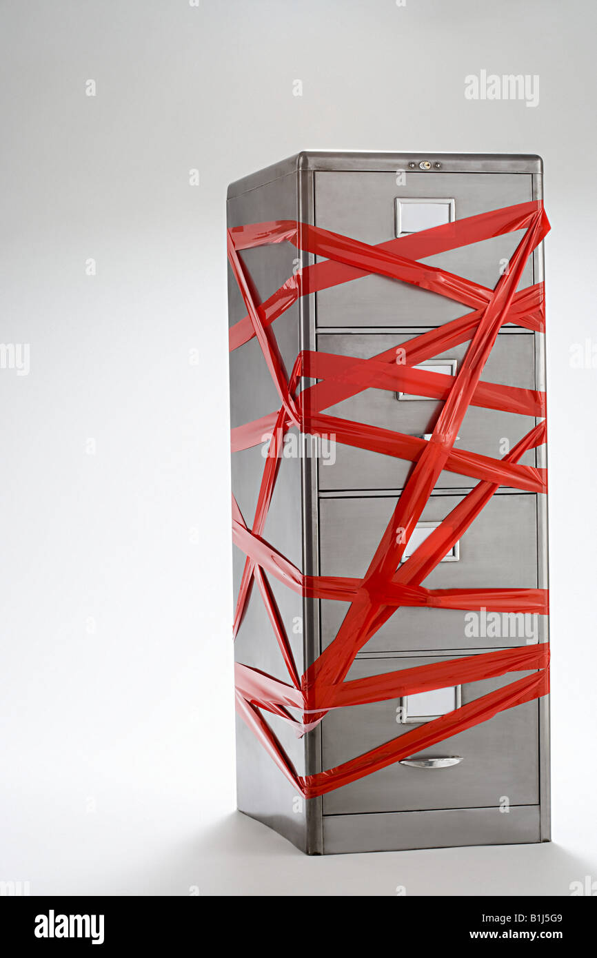 Red tape over filing cabinet Stock Photo