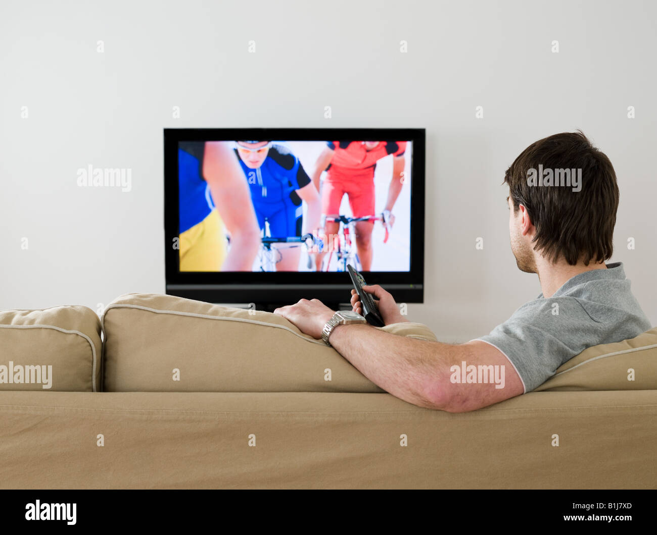 A man watching cycling on the tv Stock Photo