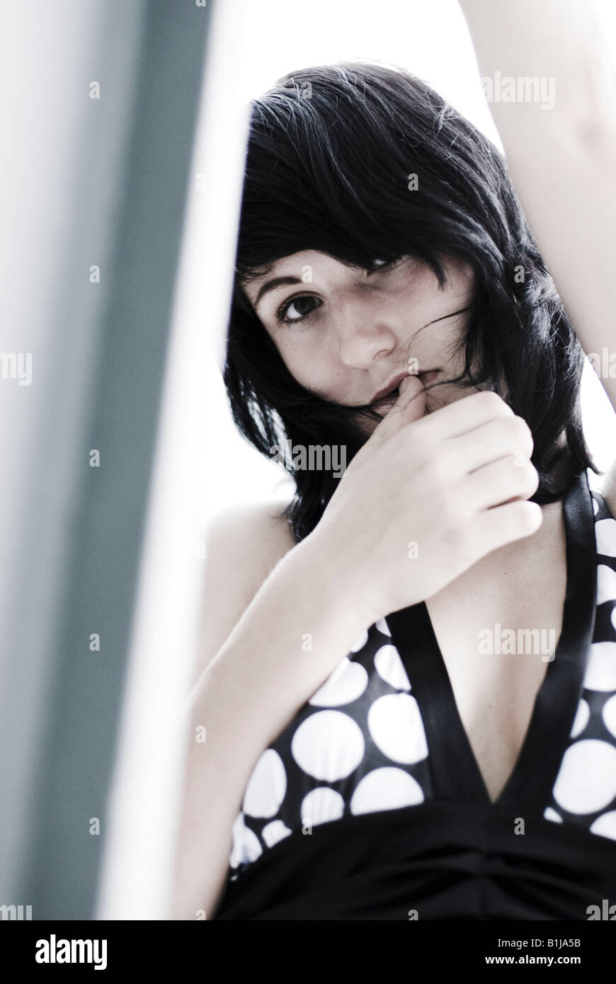 young woman wearing a black and white dress, looking shy Stock Photo ...