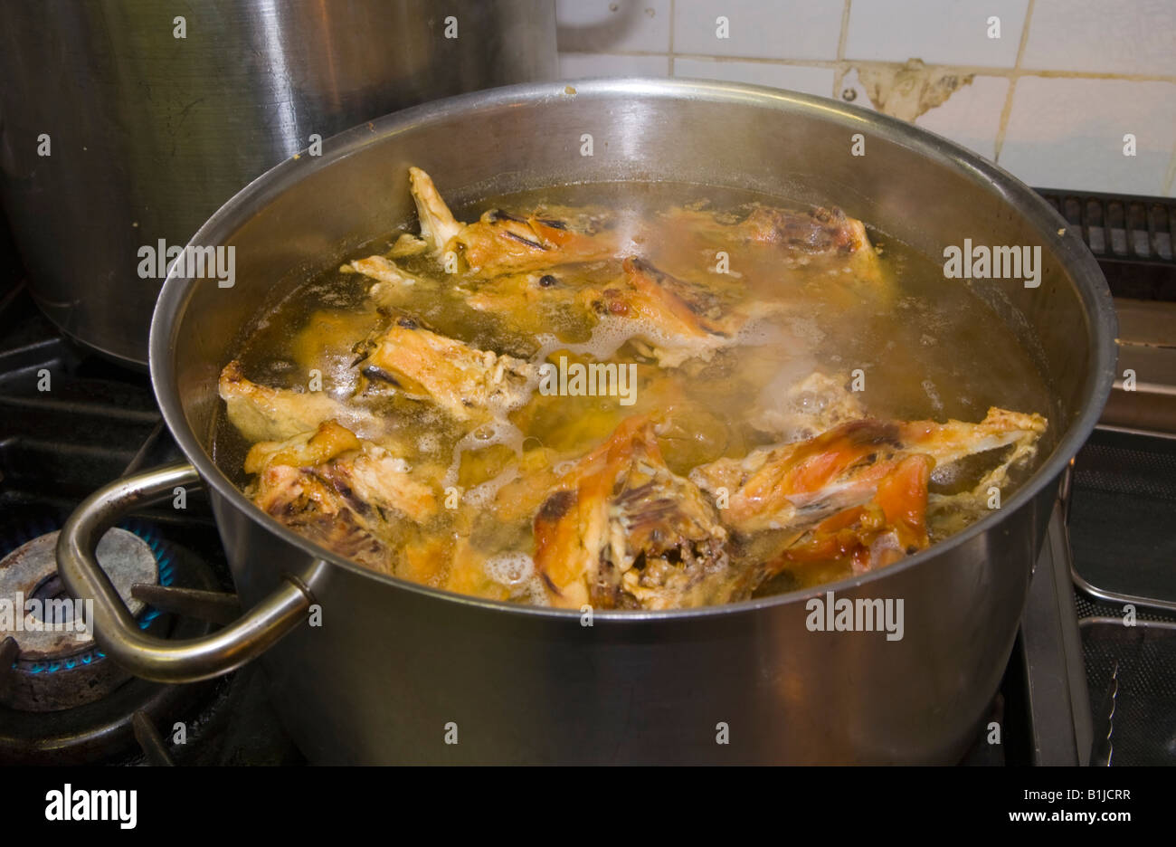 Pan of stock simmering on the stove at The Walnut Tree Restaurant Llanddewi Skirrid Abergavenny Monmouthshire Wales UK Stock Photo