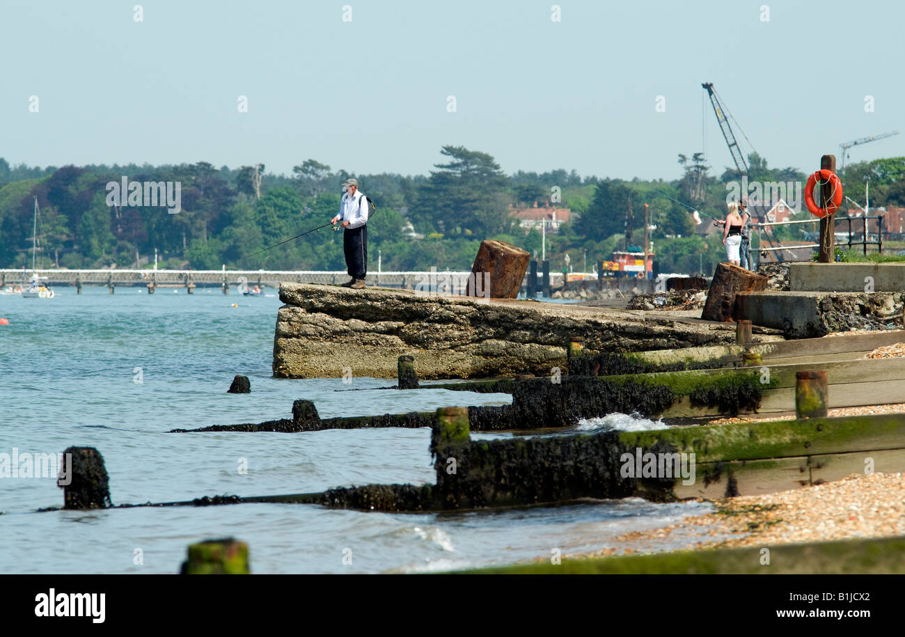 beach sceen showing shore line sea groins and a man fishing Stock Photo