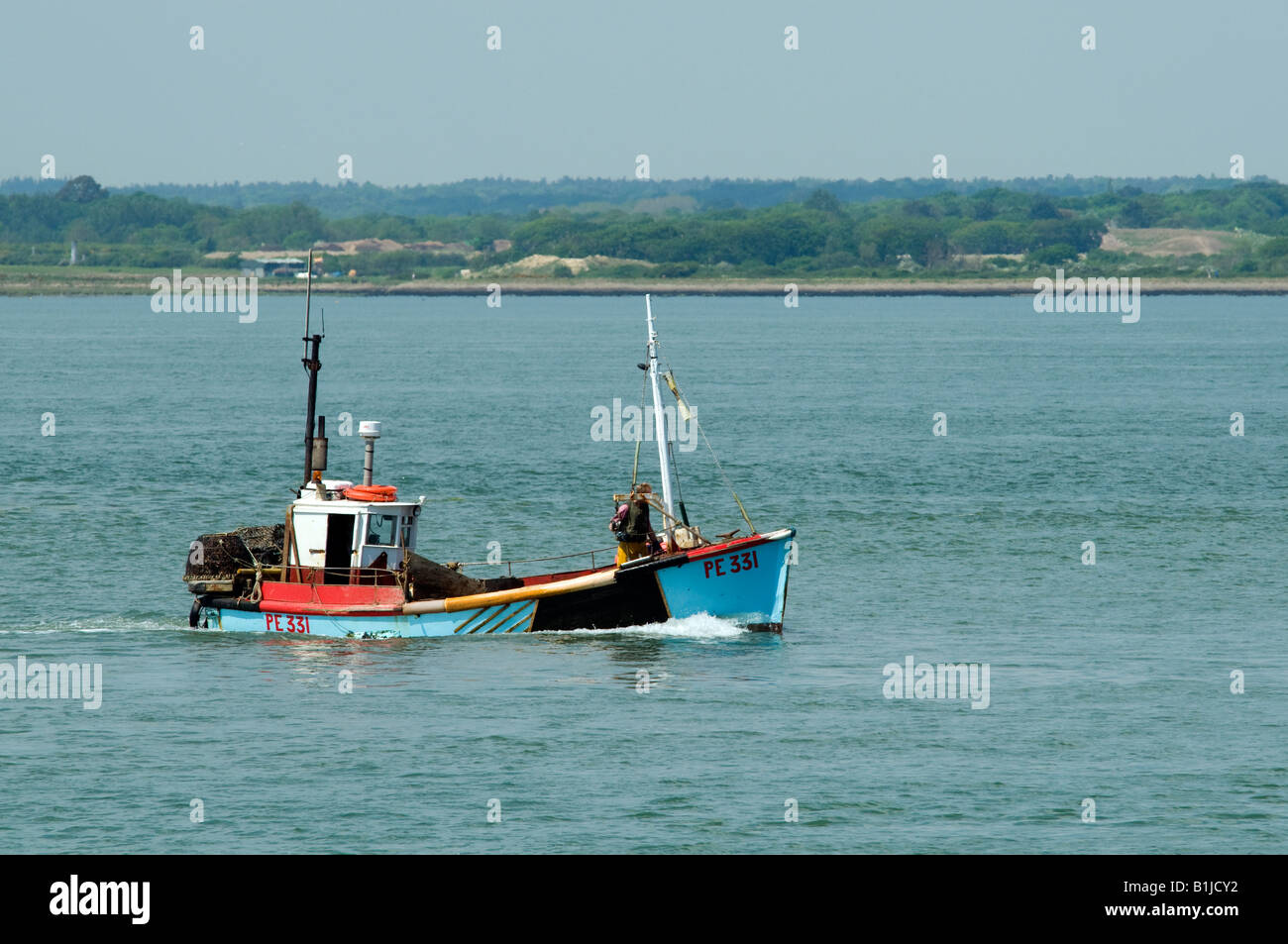 blue and red fishing boat on the sea under way Stock Photo