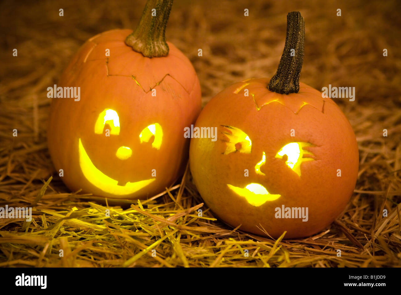 Close up of small Jack-O-Lanterns laying in hay. Stock Photo
