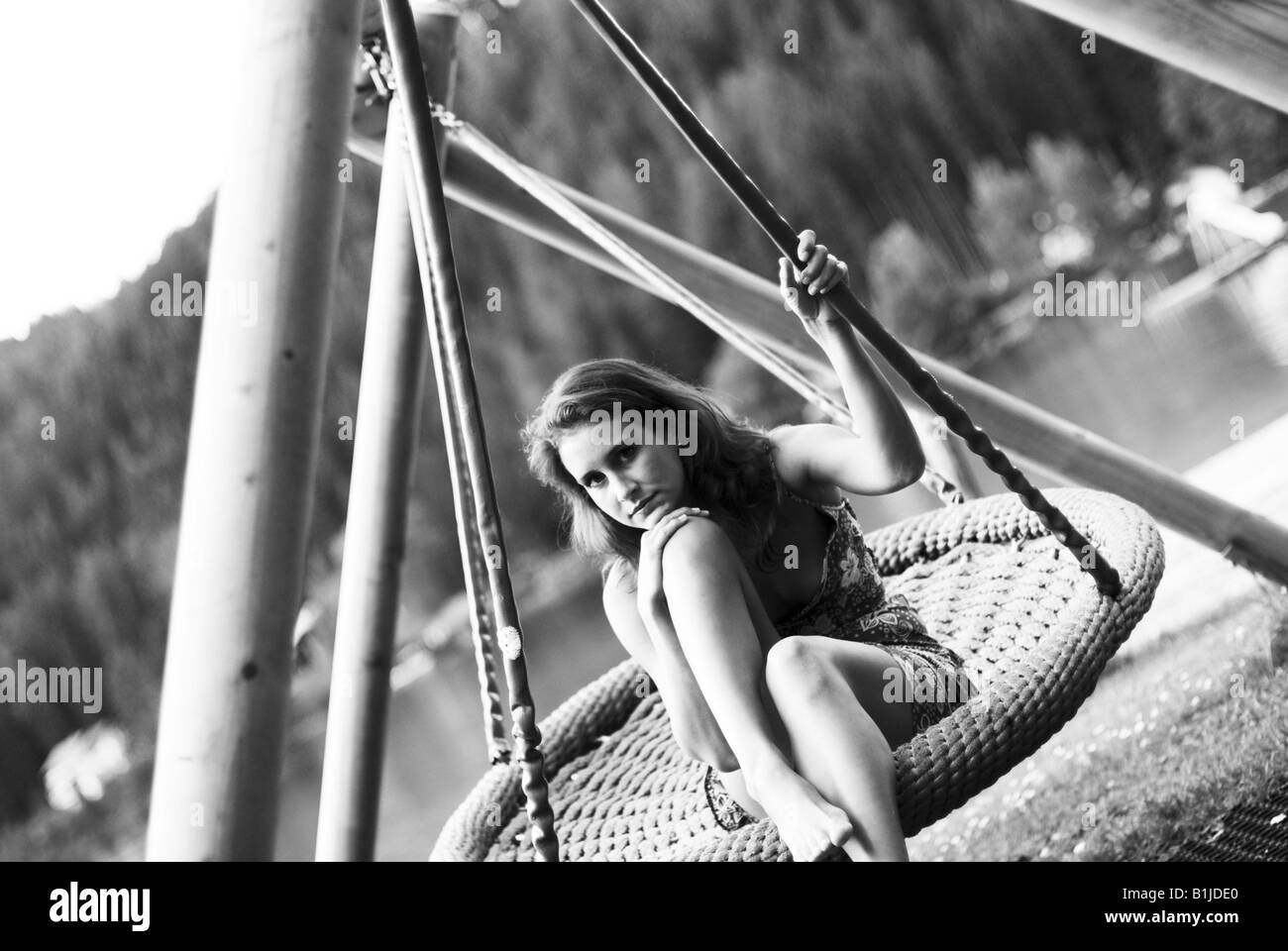 young woman sitting in a swing Stock Photo