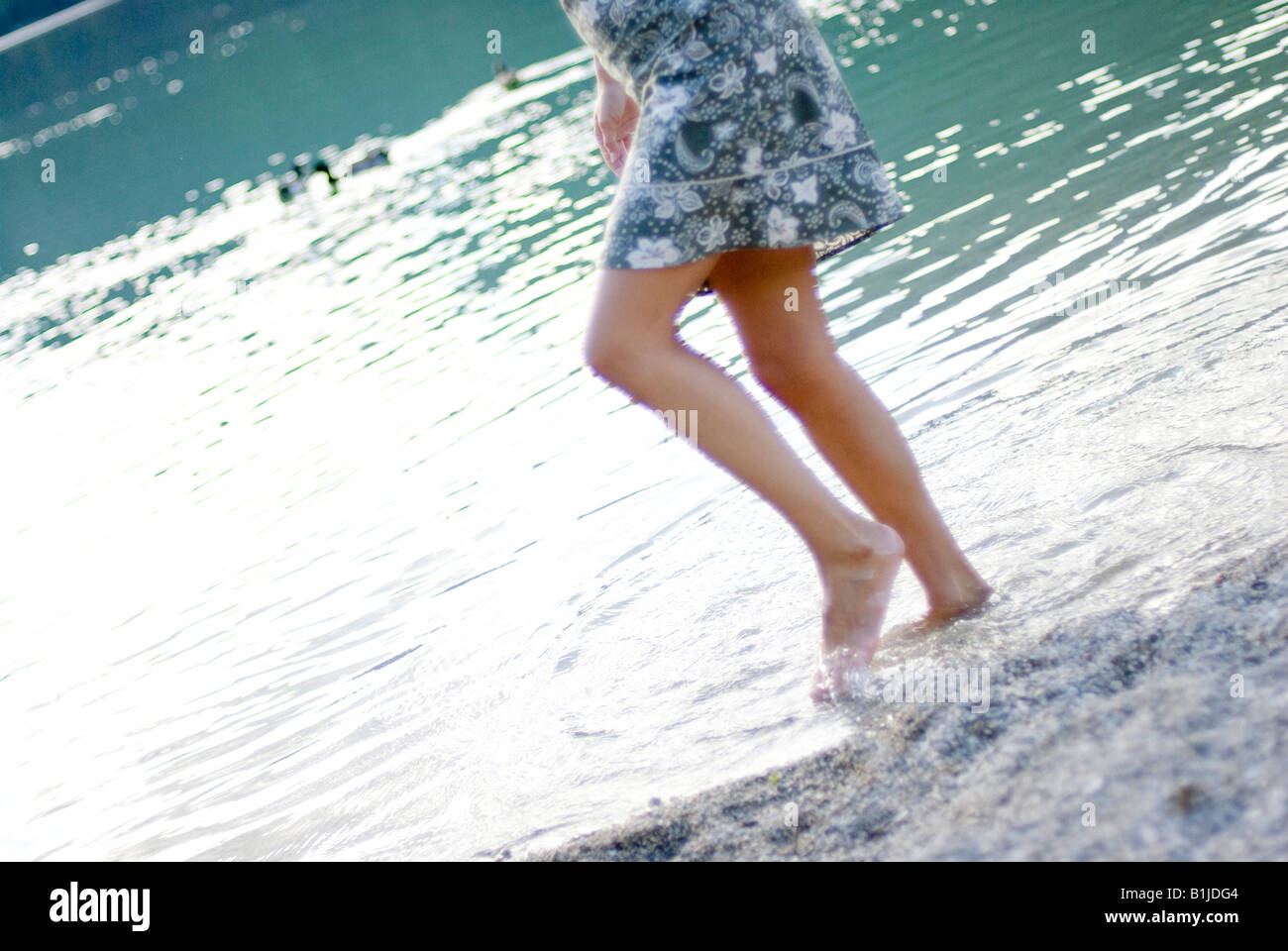 Woman wading in water in a dress hires stock photography and images