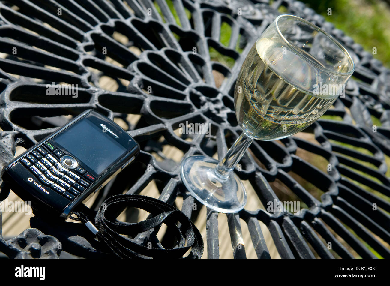 Lifestyle image of a glass of white wine and a blackberry mobile phone with email and a lanyard keys buttons Stock Photo