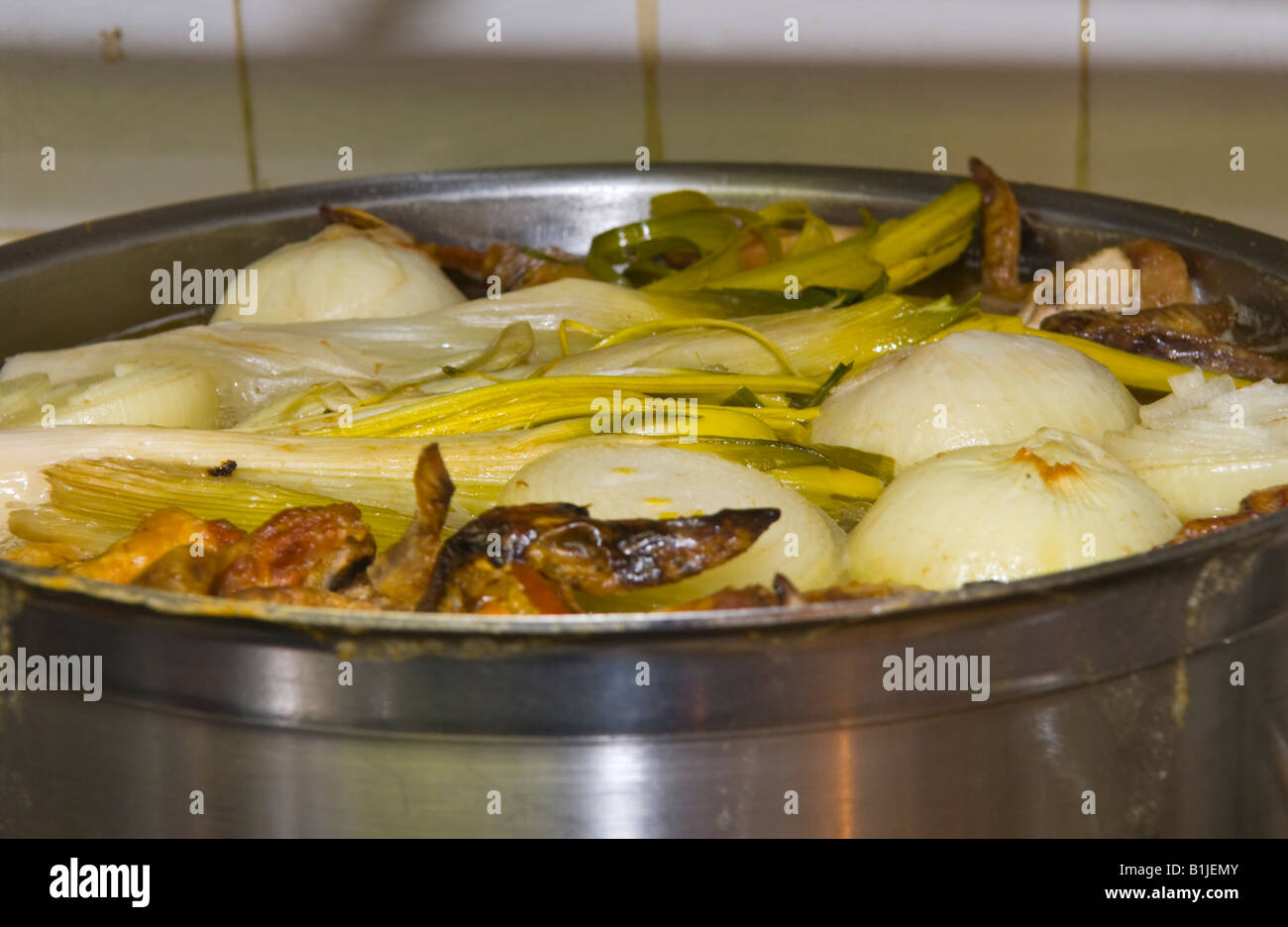 Pan of vegetable stock simmering on the stove at The Walnut Tree Restaurant Llanddewi Skirrid Abergavenny Monmouthshire Wales UK Stock Photo