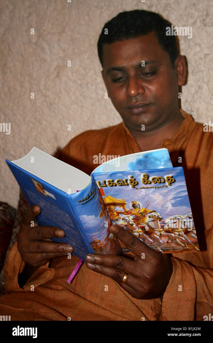 Hindu Man reading The Bhagavad Gita , A Hindu Holy book , in the Indian language Tamil India Stock Photo