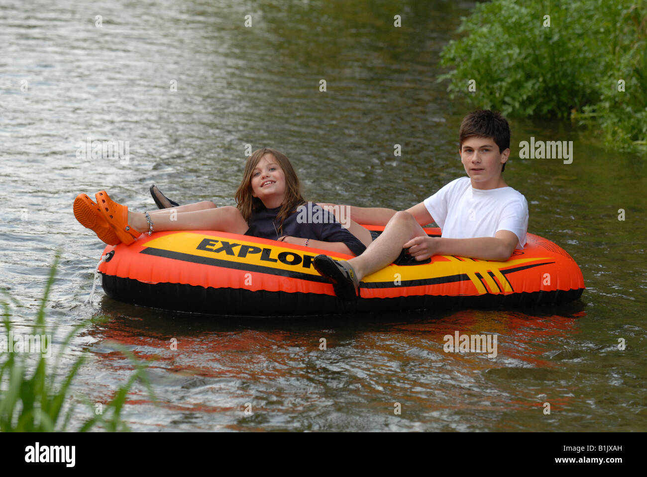 Two children playing in an inflatable dinghy boat on river Stock Photo Alamy