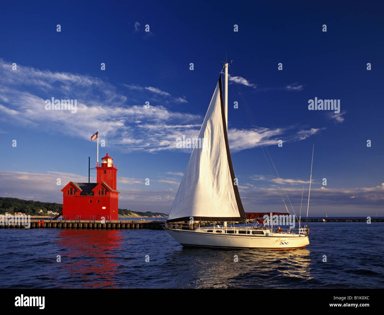 Sailboat Motoring Past the Holland Harbor Lighthouse on Lake Michigan