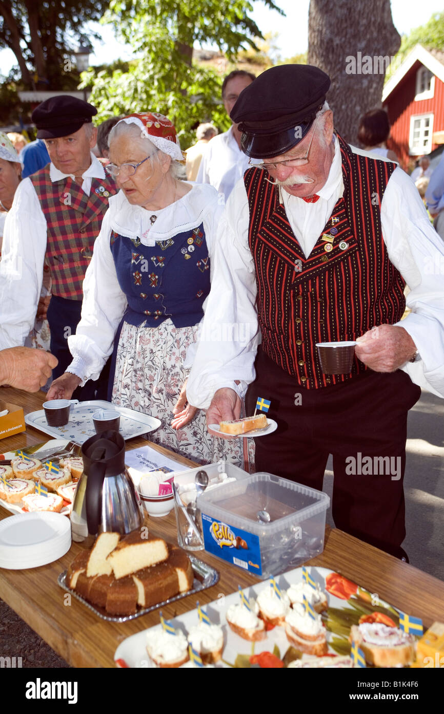 Senior citizens in traditional folk dress serving themselves at garden