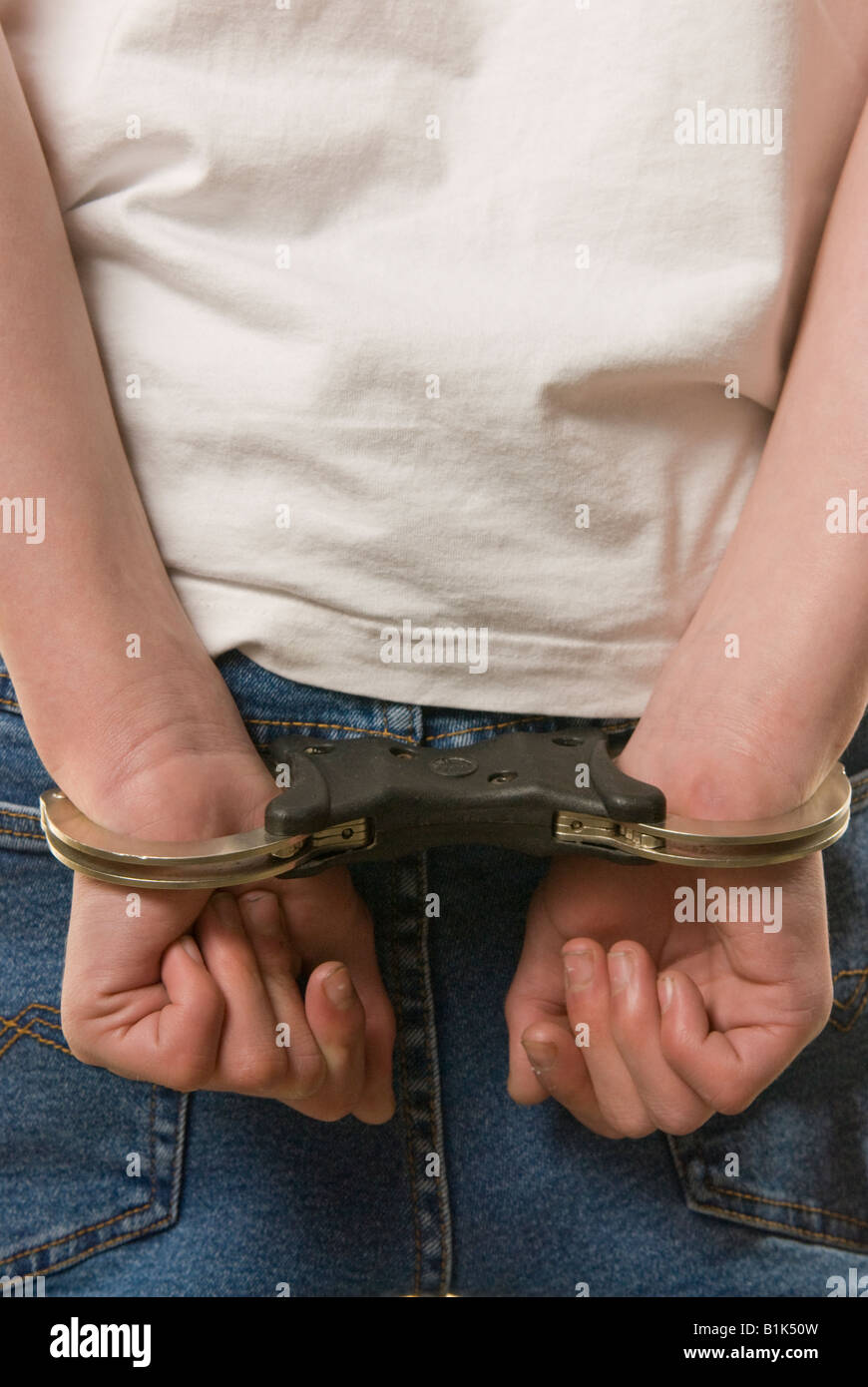 Hands cuffed behind back Stock Photo