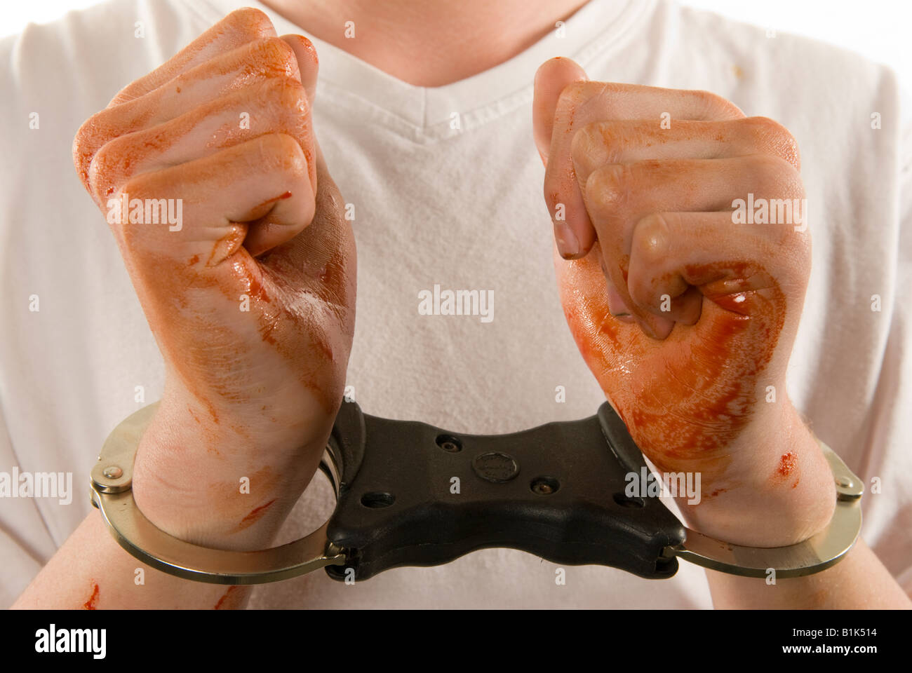 Handcuffed and bloody hands held up for inspection Stock Photo