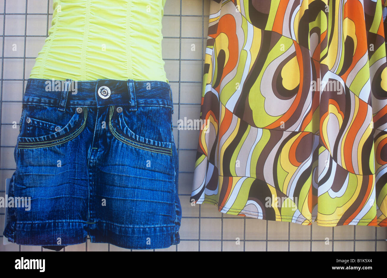 Detail of fairly cheap looking womens clothes on display outside shop with denim shorts crimplene top and retro 1970s psychedeli Stock Photo