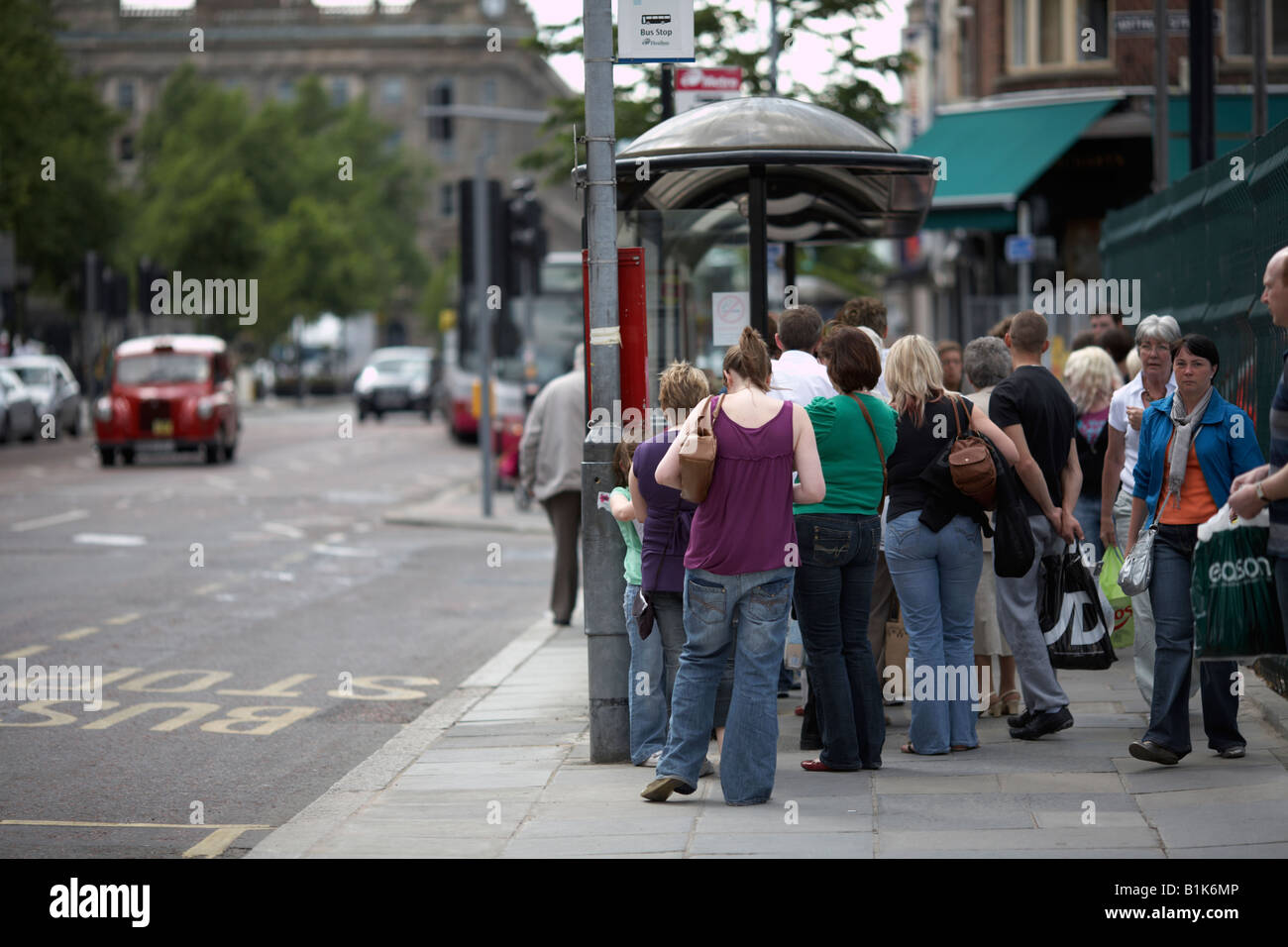 people queuing at a bus stop during saturday shopping belfast northern ireland Stock Photo