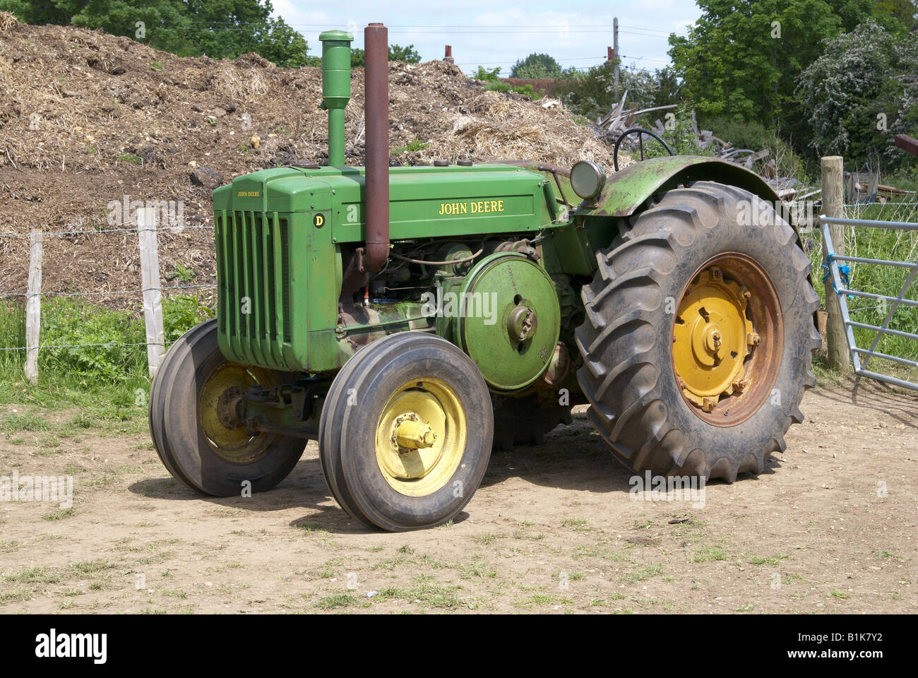 Vintage John Deere tractor in unrestored workaday condition on a farm