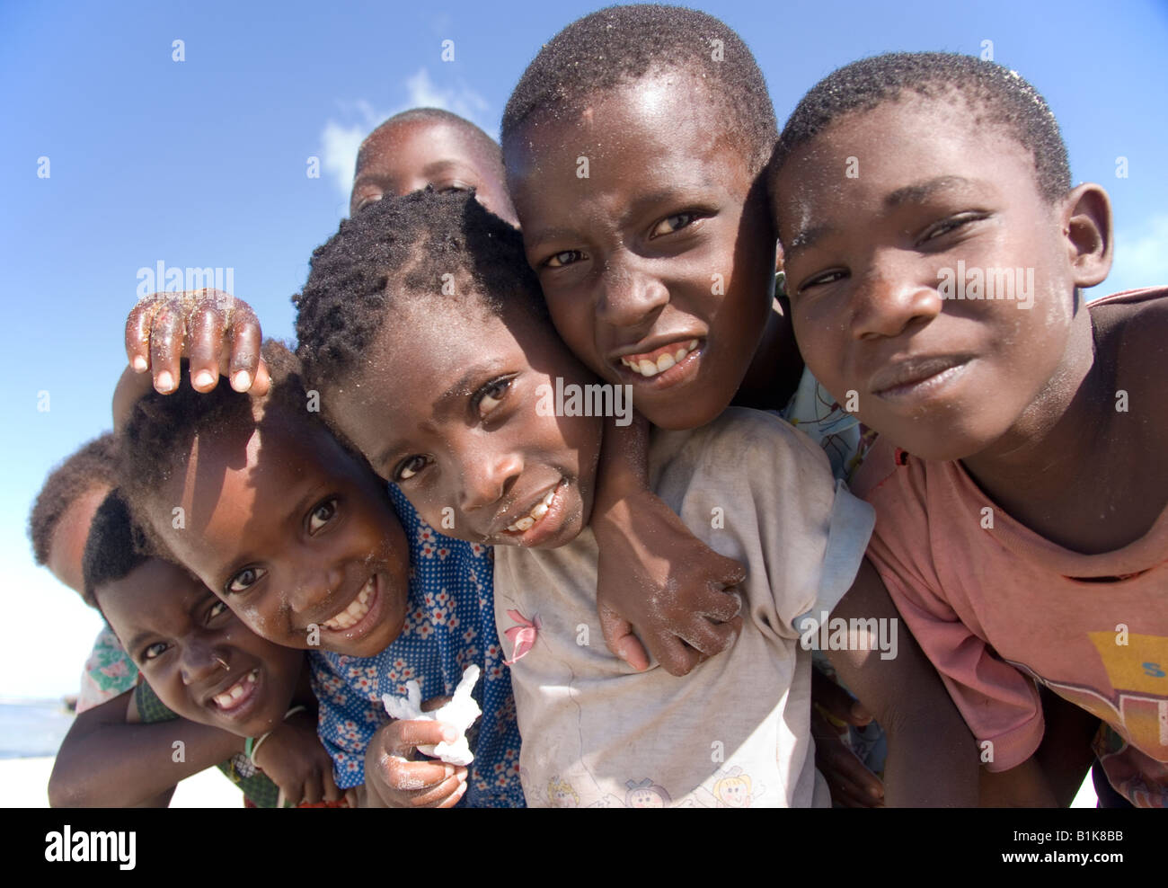 Group of happy children clinging together on the beach of Pangane ...