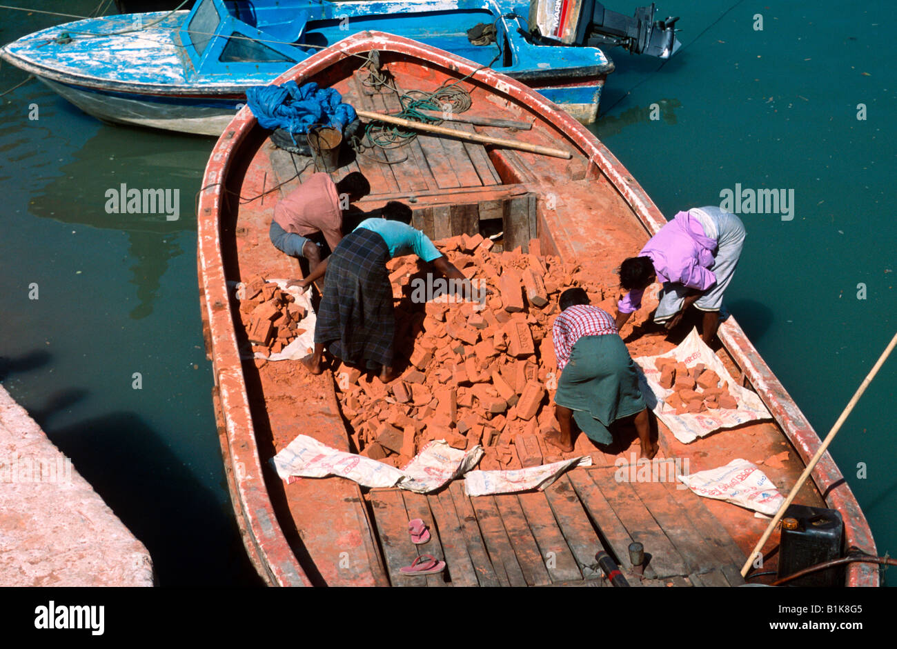 Workers sorting brick rubble transported in a boat Moheskhali island near Cox s Bazaar Bangladesh Stock Photo