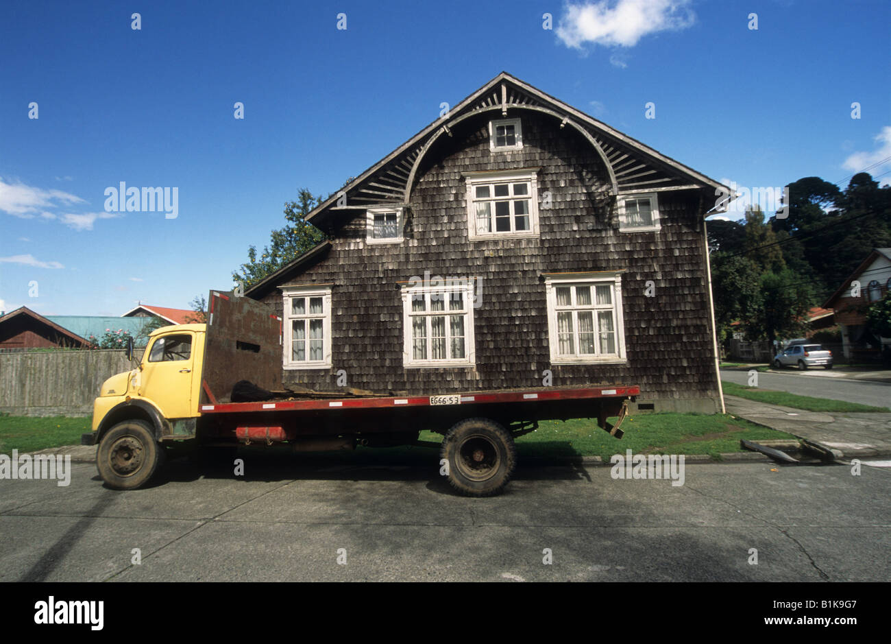 Old fashioned flat bed truck and traditional wooden house, Puerto Varas, Región de Los Lagos, Chile Stock Photo