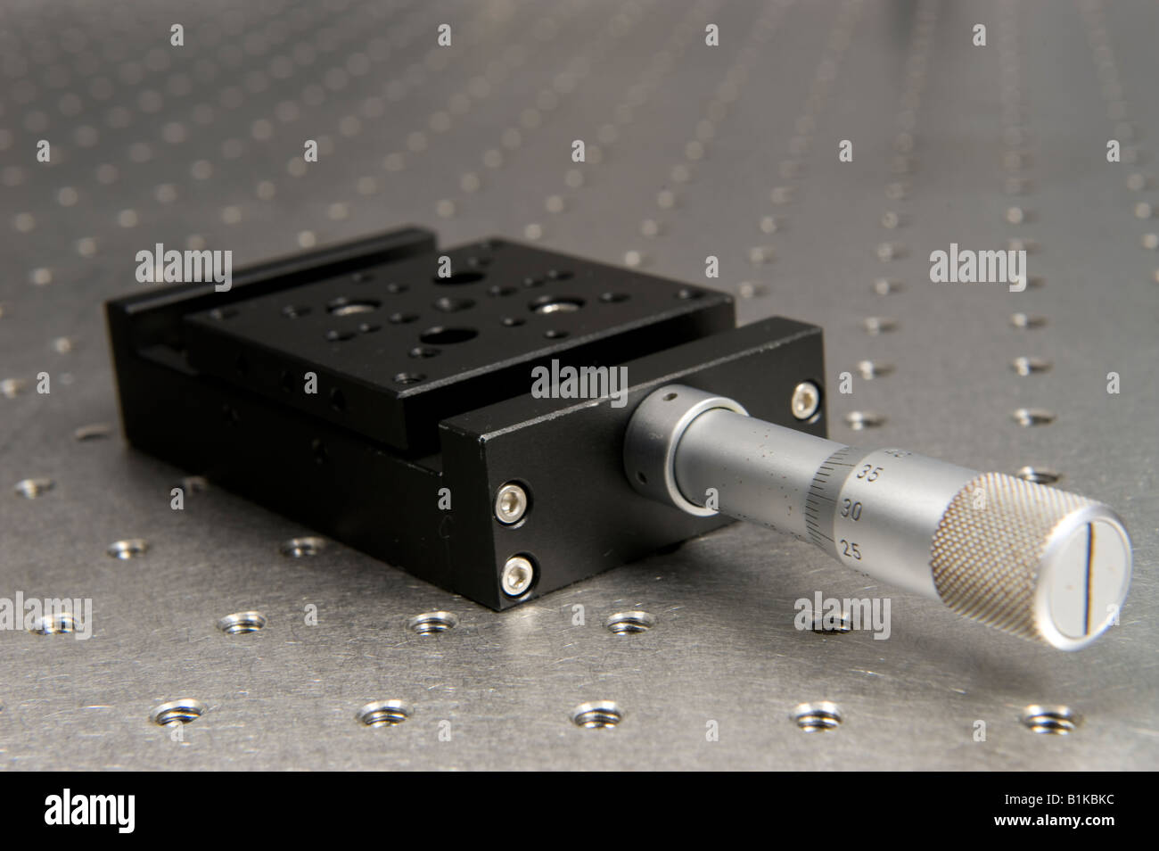 A micrometer driven translation stage on an optical bench Stock Photo