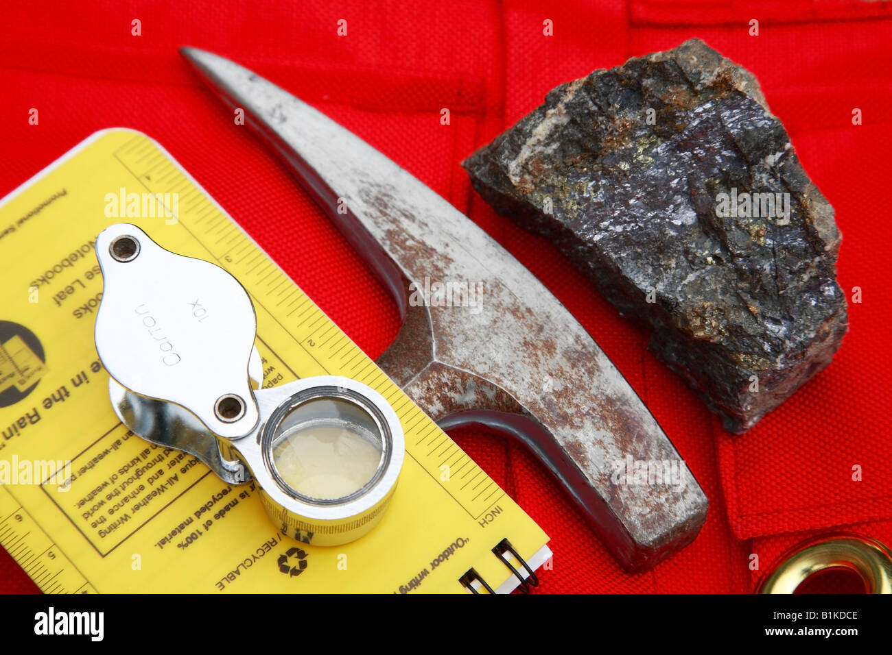 Mining  concept of ore sample, geologists rock hammer, and magnifier Stock Photo