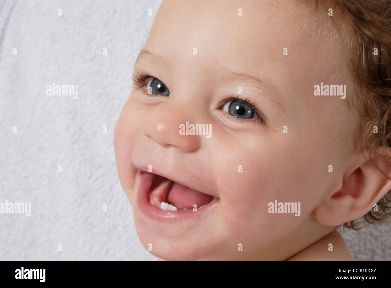 portrait little baby laughing to reveal two bottom teeth Stock Photo