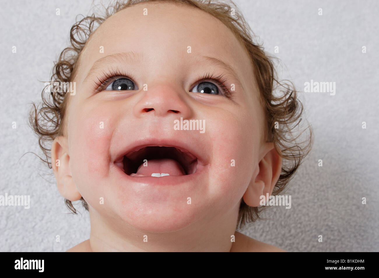 portrait little baby laughing to reveal two bottom teeth Stock Photo