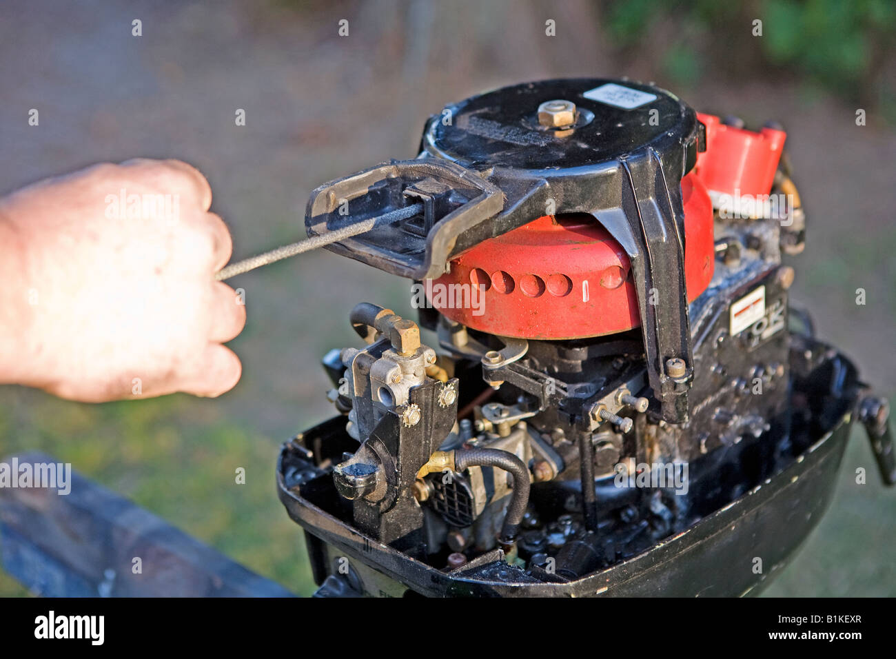 Image of an exposed boat motor pull start being pulled by hand Stock Photo Alamy