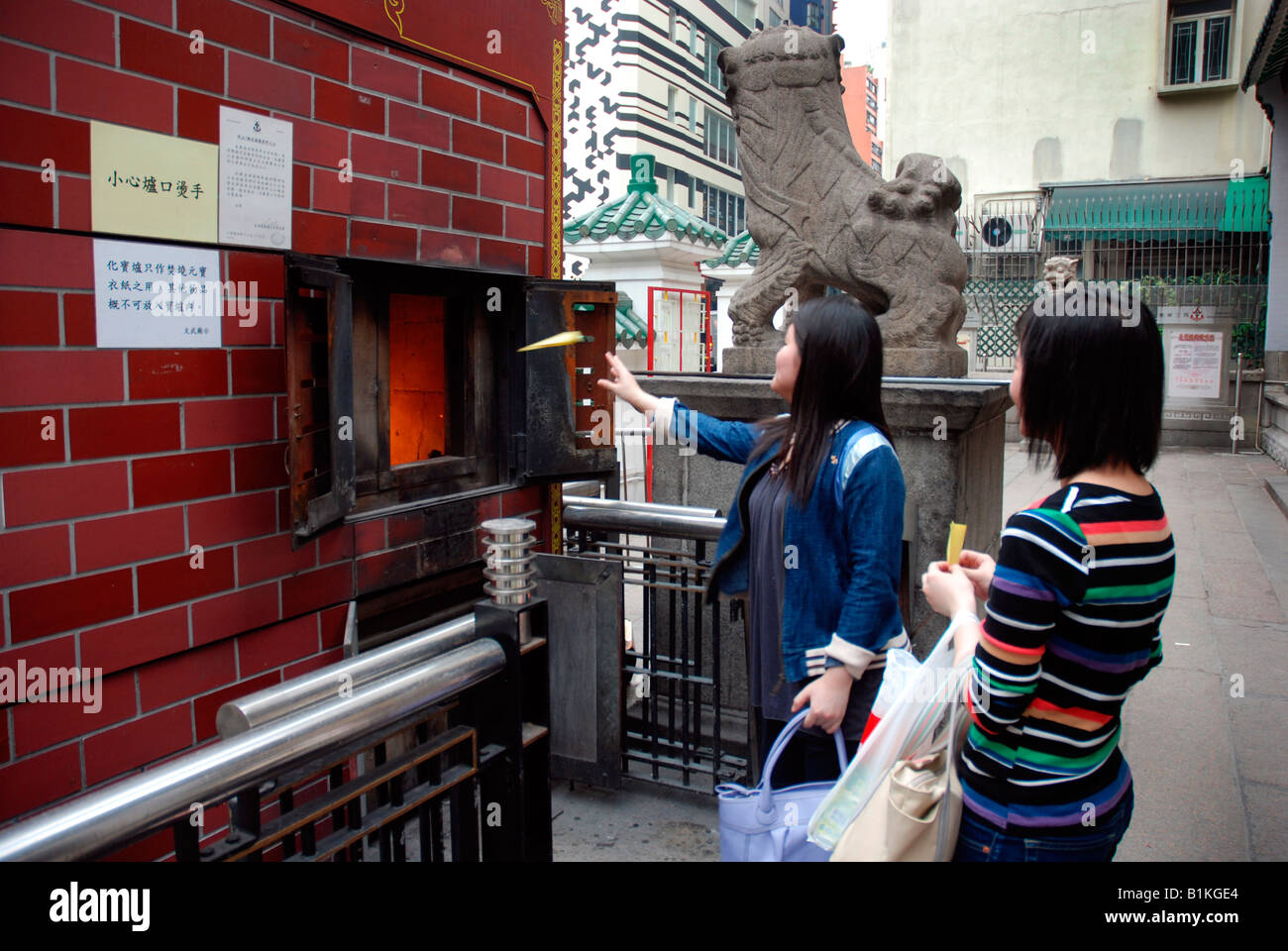 Worshipers burning paper for good luck Man Mo Taoist temple in Hong Kong China Stock Photo