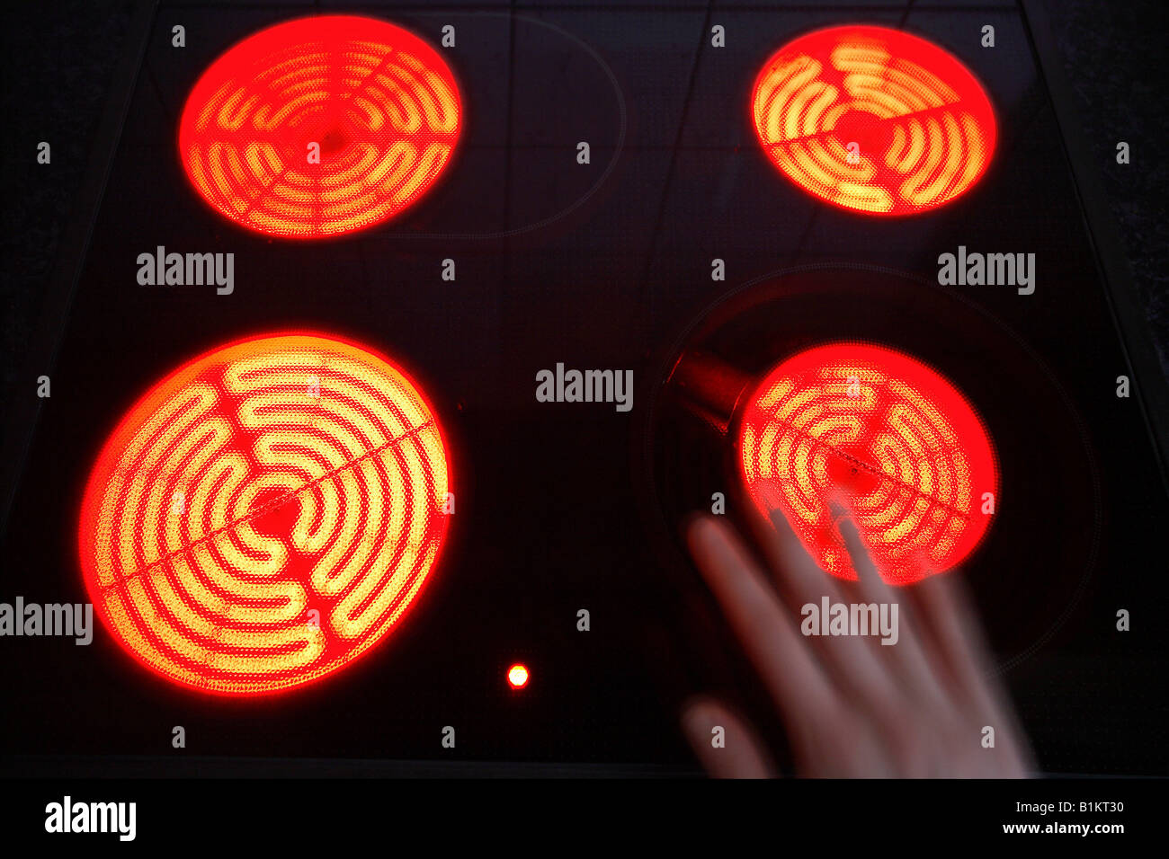 Burning hotplates of an induction cooker and a hand Stock Photo Alamy