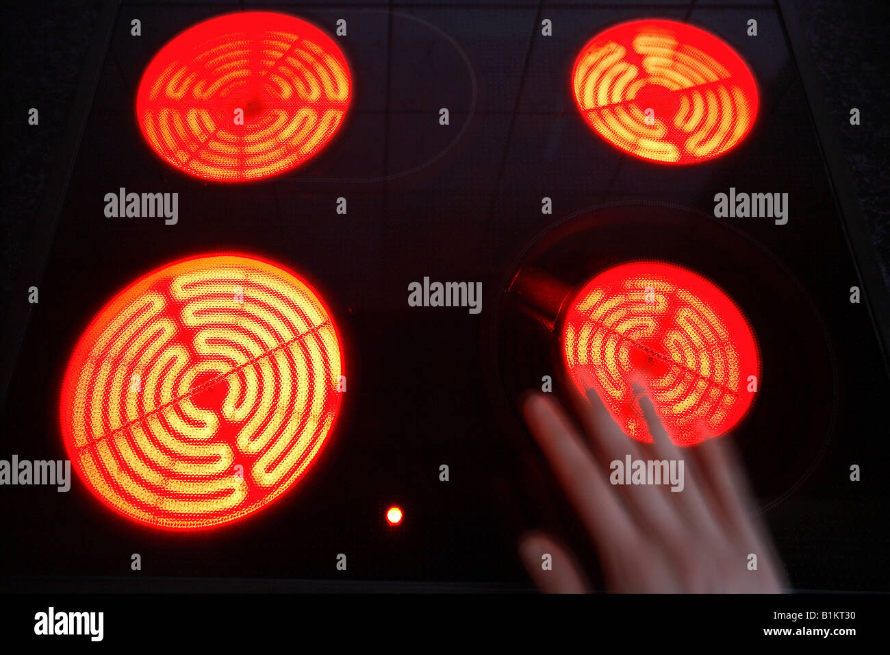 Burning hotplates of an induction cooker and a hand Stock Photo - Alamy
