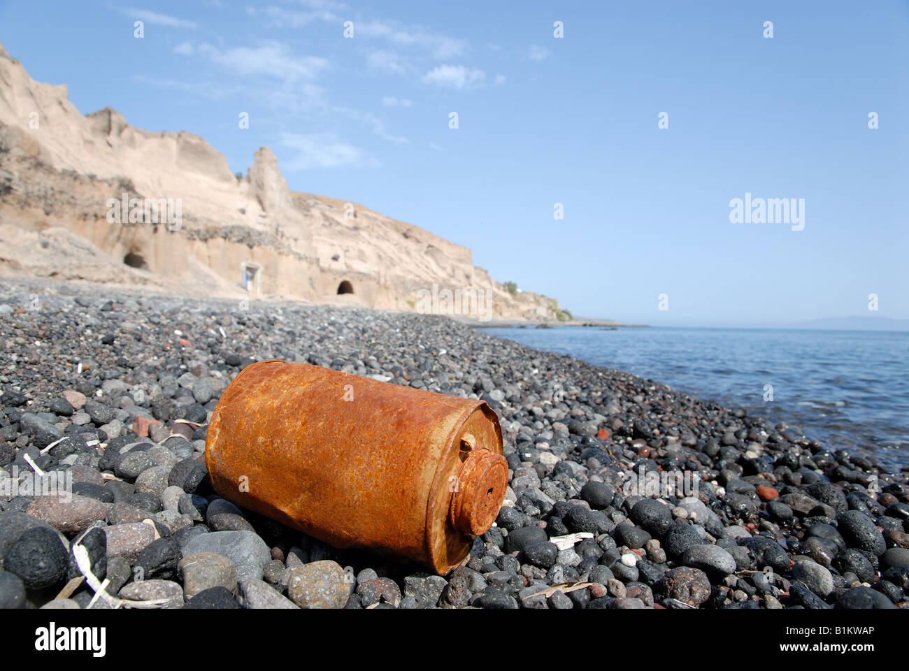 Rusty can on the beach in Santorini, Greece Stock Photo