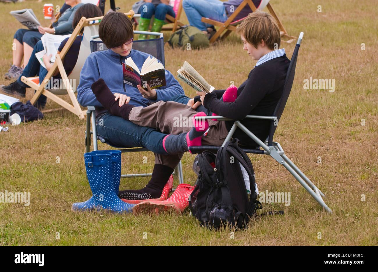 People sat in chairs on grass reading at The Guardian Hay Festival 2008 Hay on Wye Powys Wales UK EU Stock Photo