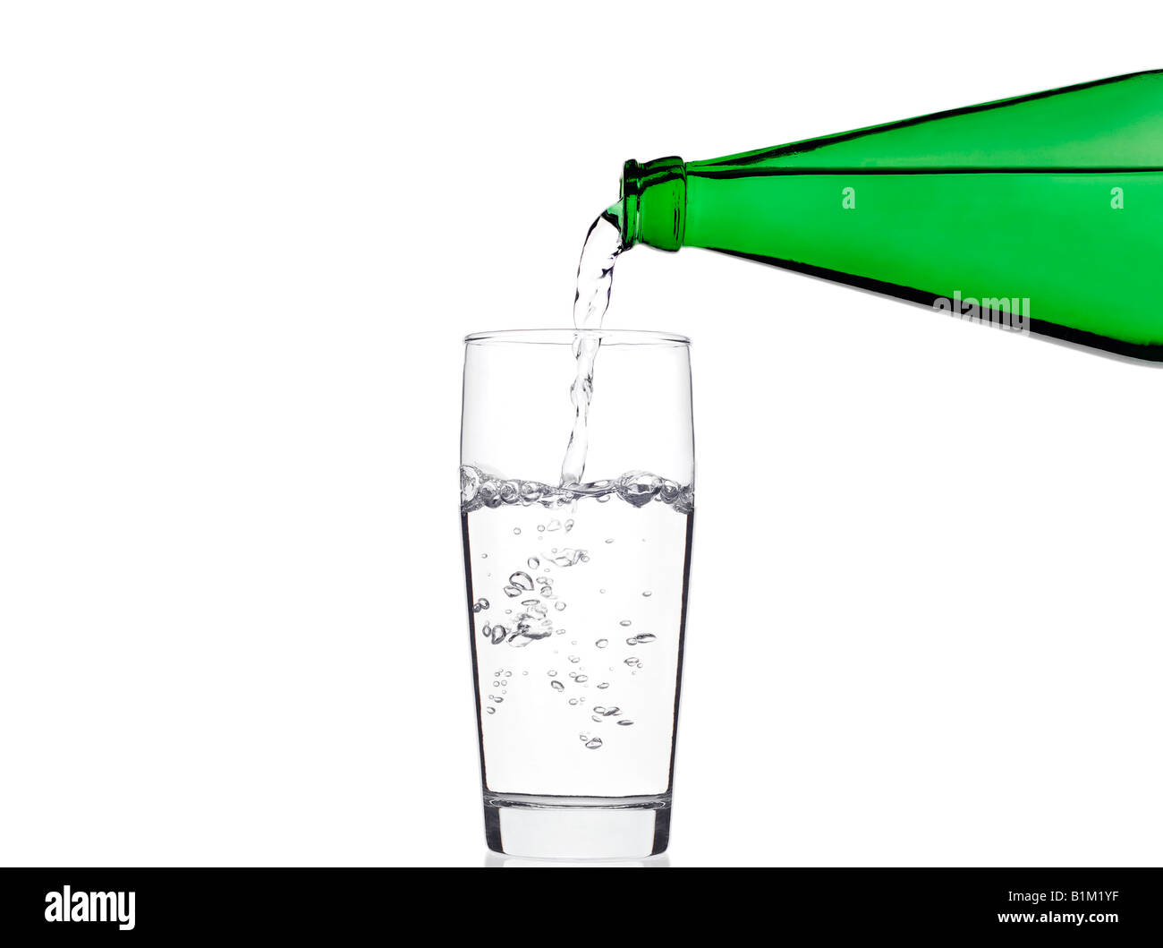 Pouring Water into a Glass Against a White Background Stock Photo