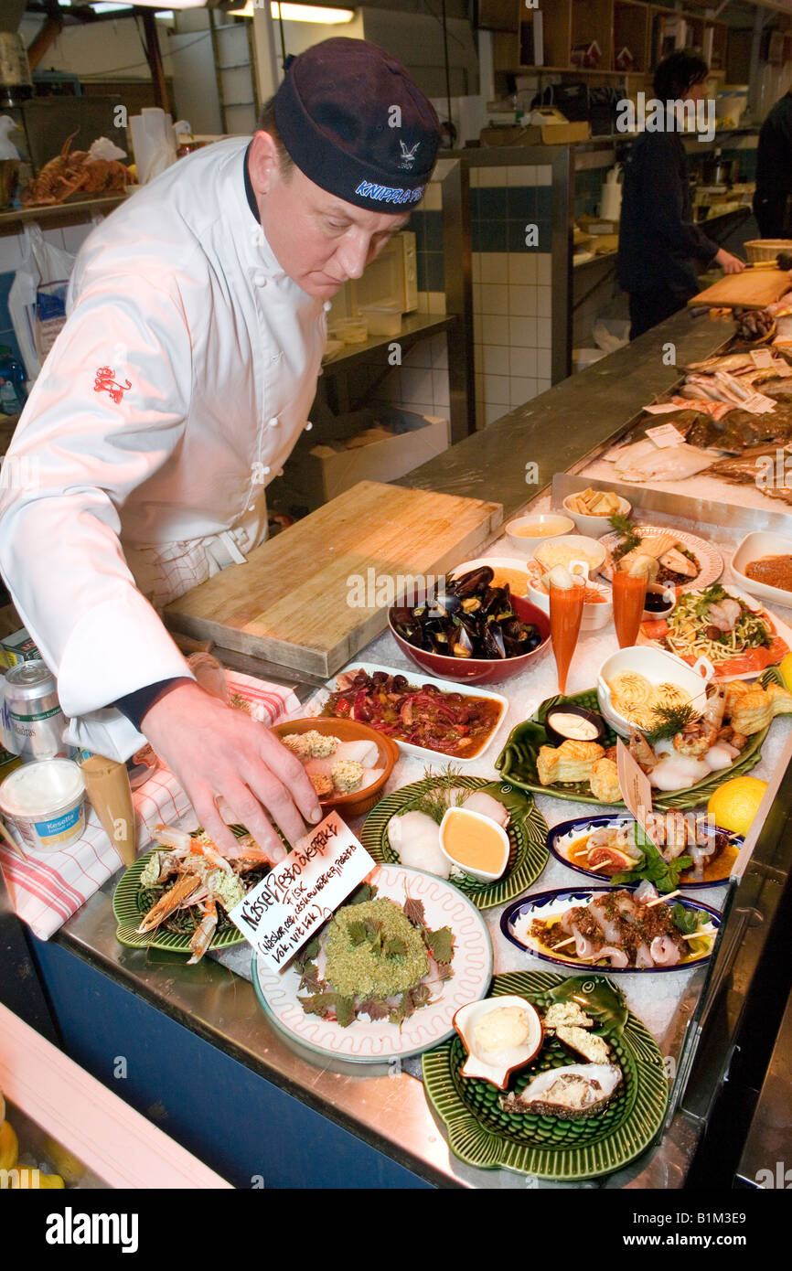 Chef and fishmonger Friedrik Liebig tags his seafood and fish specialities on counter at fish market Fiskekörka Gothenburg Swede Stock Photo