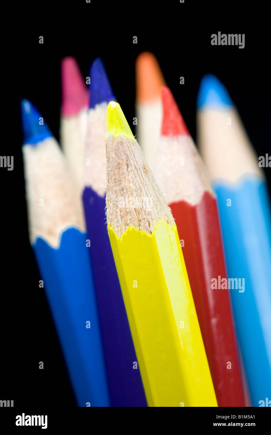 Coloured pencils with a black background. Focus on the yellow pencil Stock Photo