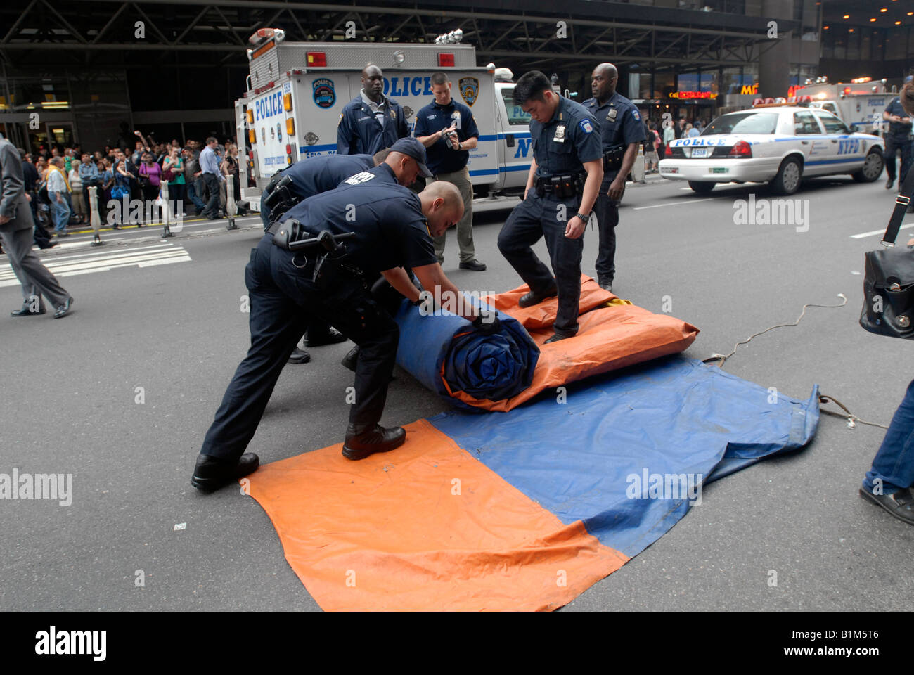 NYPD ESU officers roll up an airbag after a climber scales the New York Times building in New York Stock Photo