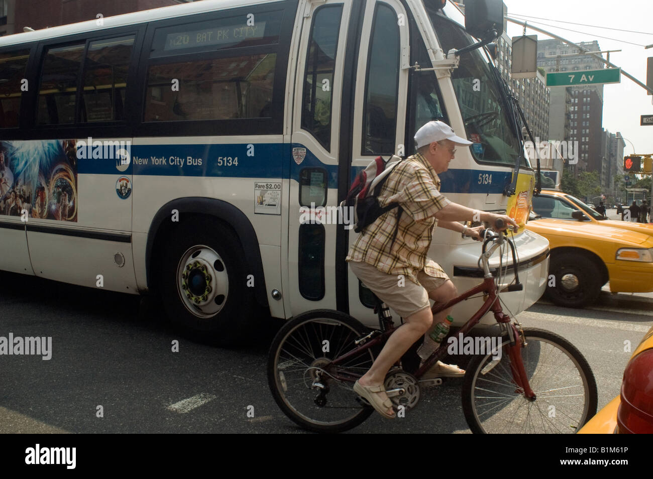 Maneuvering through traffic on a bicycle and narrowly avoiding a bus in New York Stock Photo