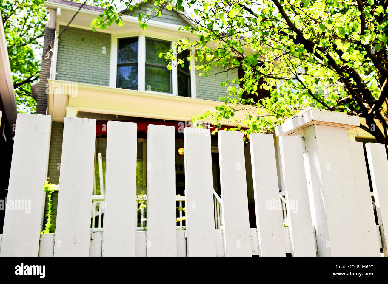 White fence around front yard of residential house Stock Photo