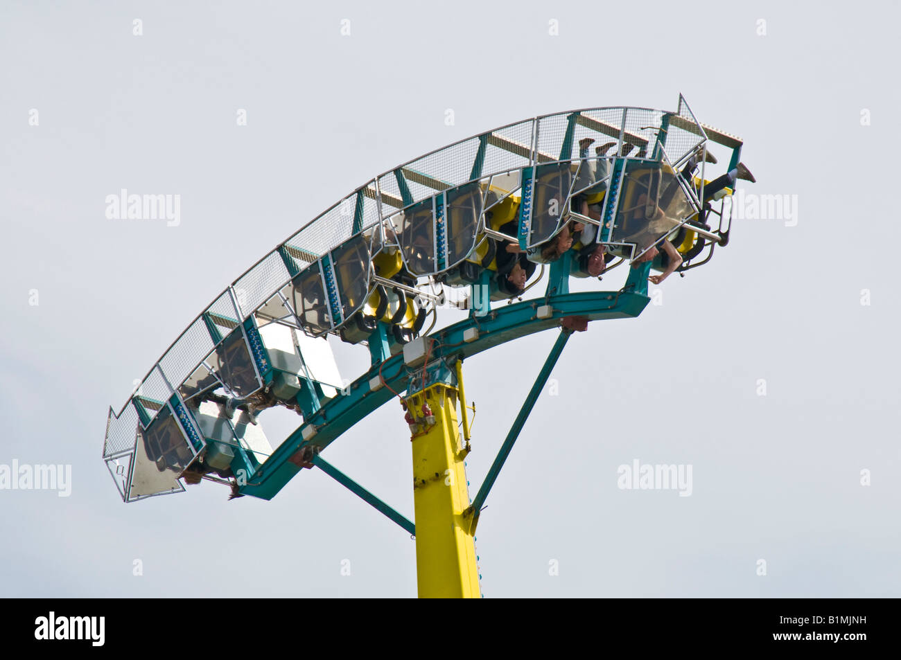 People upside down in fairground ride showing safety caging and other safety features Stock Photo